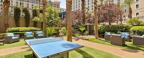 A courtyard with a ping pong table, outdoor seating, and palm trees. - Las Vegas Resort Near Strip Wyndham Grand Desert 1BR Deluxe Sleeps 4 (Las Vegas)