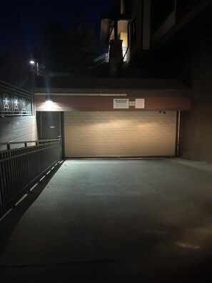 A parking garage entrance with a 'Reserved Parking' sign, a metal gate, and a closed garage door. - Cozy 1-bedroom loft condo Elkhorn in Sun Valley with gas fireplace and A/C (Sun Valley)
