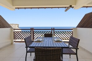 A balcony with a table set for two, overlooking the sea. - One Bedroom Oceanfront - Puerto Escondido 1361 (Bajos de Chila)