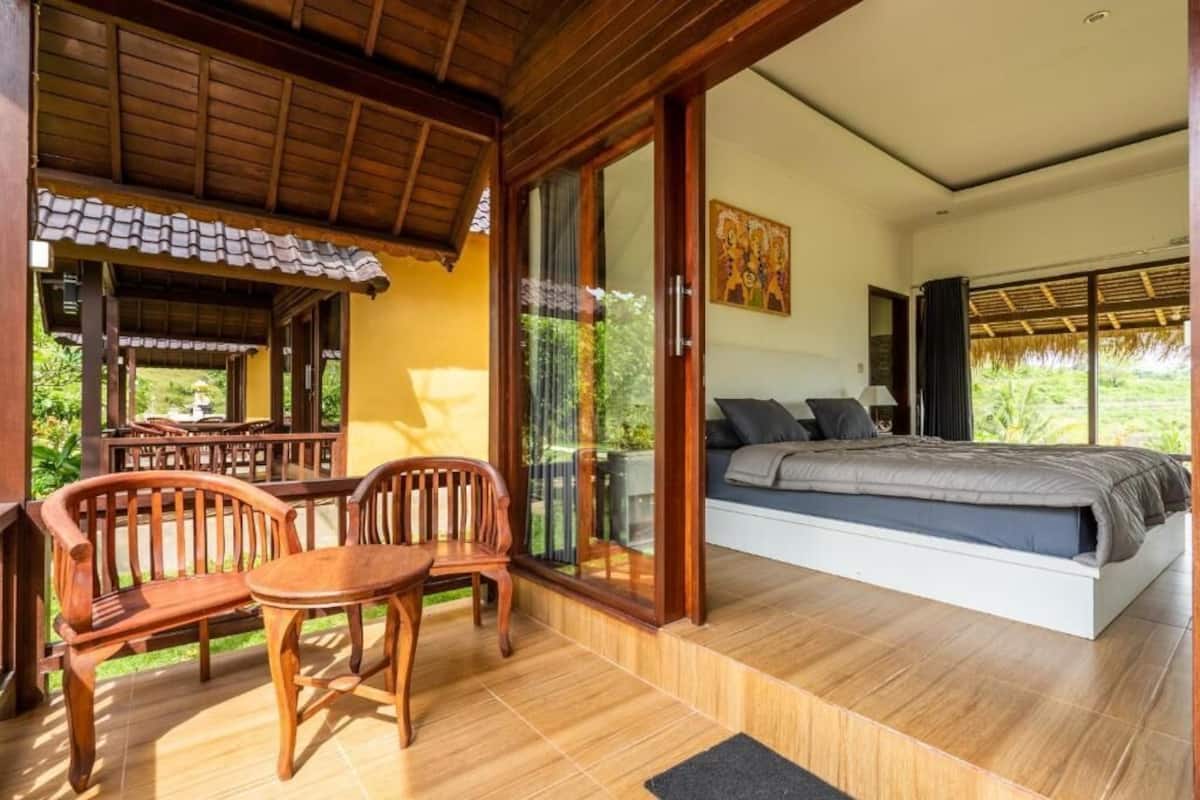 Quarto com cama, sofá, mesa e cadeiras.