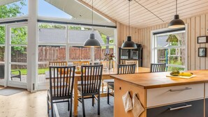 A modern kitchen with a large island, wooden ceiling, and large windows. - "Sissa" - 700m from the sea by Interhome (Væggerløse)
