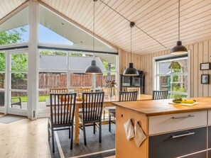 A modern kitchen with a large island, wooden ceiling, and large windows. - "Sissa" - 700m from the sea by Interhome (Væggerløse)