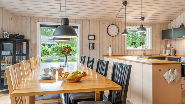 A modern kitchen with wooden cabinets, a central island, and pendant lighting. - "Sissa" - 700m from the sea by Interhome (Væggerløse)