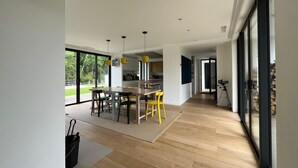 Una cucina moderna con zona pranzo, ampie finestre e un camino.