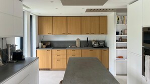 Una cucina moderna con mobili in legno, un'isola centrale ed elettrodomestici integrati.