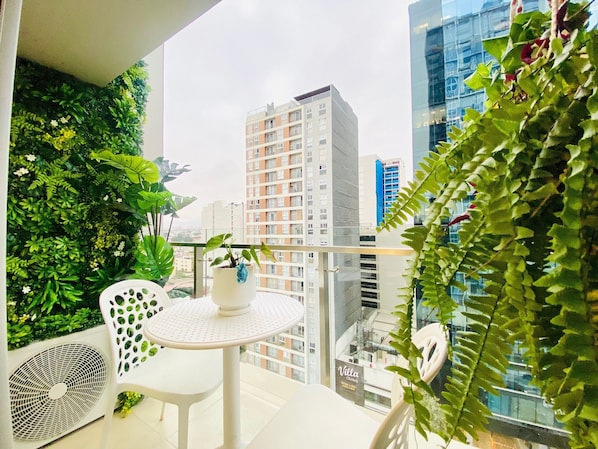 Ein Balkon mit einem Blumentopf, einem kleinen Tisch und einem Stuhl.