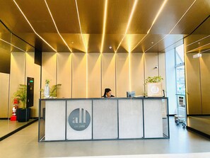 A reception desk with a modern design, a digital screen, and a plant. - Executive Apart San Isidro Pool Gym AC (San Isidro)