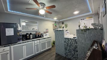 Una cocina moderna con una isla integrada, refrigerador y ventilador de techo.