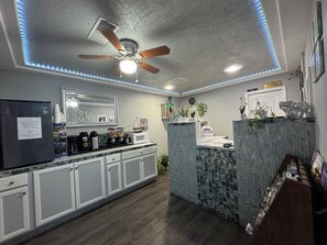 A modern kitchen with a built-in island, a refrigerator, and a ceiling fan. - Budget Inn Ontario (Ontario)