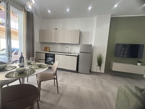 Eine moderne Küche mit Essbereich, einem Einbauofen und einem Kühlschrank.
