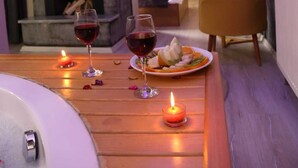 Un cuarto acogedor con chimenea, una mesa de comedor con velas y una cama al fondo.