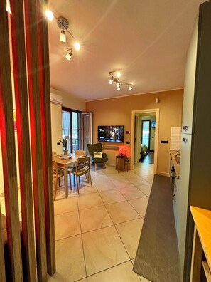 A modern living room with a TV, dining area, and kitchen. - Mazzini28, A1 Caserta Nord, Royal Palace, concerts, Naples, coast, southern Italy (Casapulla)