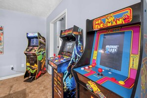 Arcade machines in a room with tiled flooring and a white door. - Spacious Retreat w/ Hot Tub & Games | Sleeps 16 (Columbus)