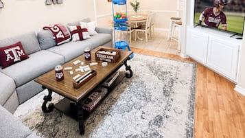 Un salon avec un canapé, une table basse et un téléviseur.
