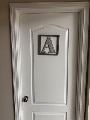 A white door with a decorative letter 'A' in a black frame. - Perfect townhome getaway in welcoming Snellville!!! W/D Connection, Room A (Snellville)