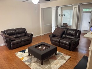 A living room with two leather sofas, a coffee table, and a rug. - Perfect townhome getaway in welcoming Snellville!!! W/D Connection, Room A (Snellville)