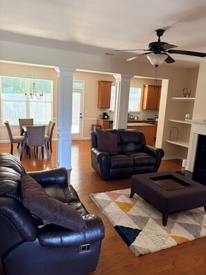 A living room with leather sofas, a coffee table, and a chandelier. - Perfect townhome getaway in welcoming Snellville!!! W/D Connection, Room A (Snellville)