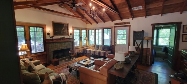 A cozy living room with a fireplace, leather sofas, and a chessboard.
