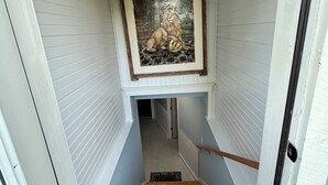 Eine Treppe mit einem gerahmten Kunstwerk darüber, das zu einer Tür führt.