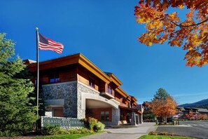 Ein Gebäude des Grand Residence Club mit einer Steinfassade, Holzbalkonen und einer amerikanischen Flagge.