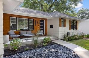 A modern house with a porch, outdoor seating, and a landscaped garden. - Moody Boho Retreat in Downtown Overland Park, Walk to Shops & Dining (Overland Park)