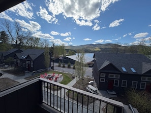 Un quartier résidentiel avec des maisons, un ciel dégagé et un lac en arrière-plan.