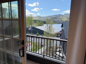 Un balcon avec vue sur un lac, des arbres et un bâtiment arborant le drapeau américain.