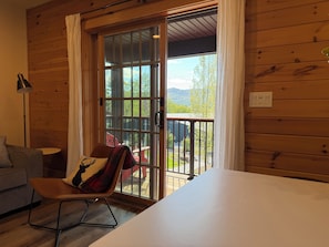 A wooden interior with a sliding glass door leading to an outdoor deck. - Deluxe Lodge Lakefront On Lake George #2 (Lake George)