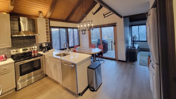 Una cucina moderna con isola centrale, elettrodomestici in acciaio inossidabile e zona pranzo con vista.