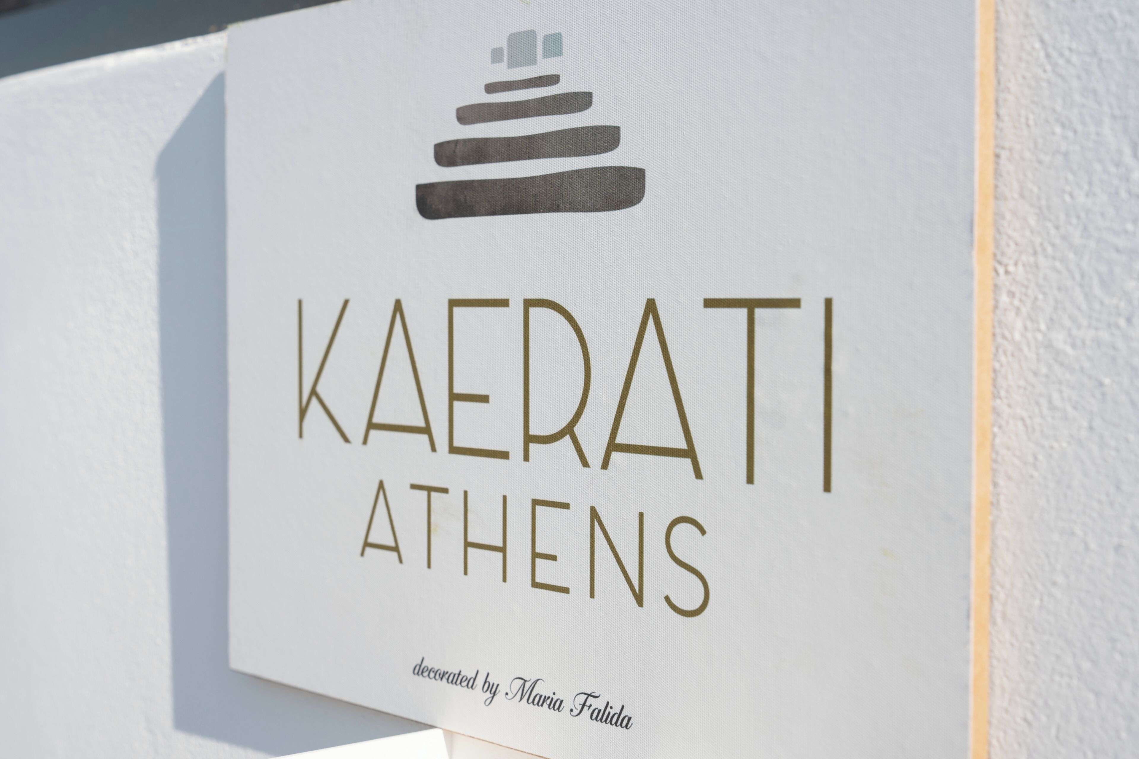 A sign with the text 'KAERATI ATHENS' and a logo above it.