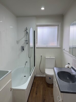 Une salle de bain avec une baignoire, des toilettes et un lavabo.