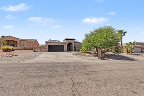 A residential driveway leading to a garage with a clear sky above.