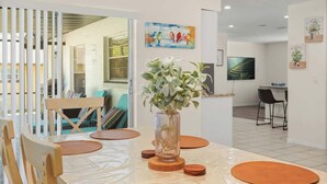 Un coin repas avec une table, des chaises et un vase de fleurs.