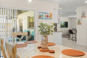 A dining area with a table, chairs, and a vase of flowers.