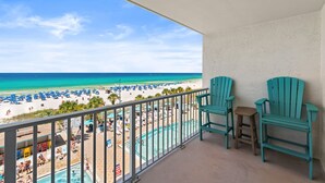 A balcony with a view of a beach, a pool, and two chairs. - The Summit 518 - Beach Front, 2 Pools, & Hot Tubs (Panama City Beach)