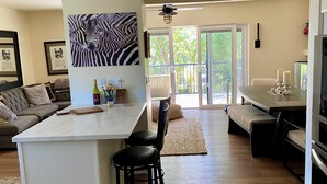 A modern kitchen with a central island, bar stools, a dining table with candles, and a ceiling fan. - Upscale, Family Friendly Coastal Retreat.
2 Blocks from So Cal’s, Seal Beach (Seal Beach)