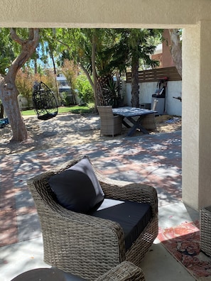 A covered patio area with wicker furniture, including a chair and a table. - Upscale, Family Friendly Coastal Retreat.
2 Blocks from So Cal’s, Seal Beach (Seal Beach)
