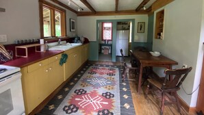 Una cocina con armarios de madera, una estufa, un fregadero y un comedor con mesa y sillas.