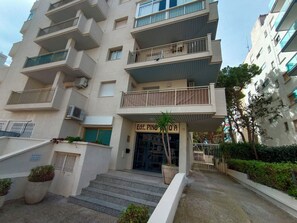 A multi-story building with balconies, a sign reading 'Edif. PINGA,' and a palm tree in the entrance area. - JESCAMAR Apartments, very close to the beach, between Capellanes and Levante Beach, (Salou)