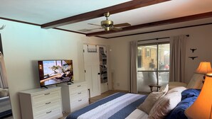 A bedroom with a bed, a TV, a ceiling fan, a window with curtains, and a lamp. - 4BR Home - Airport- UD - WPAFB - POOL -Sleeps 7 (Dayton)