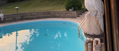 A wooden bird sculpture by a poolside.