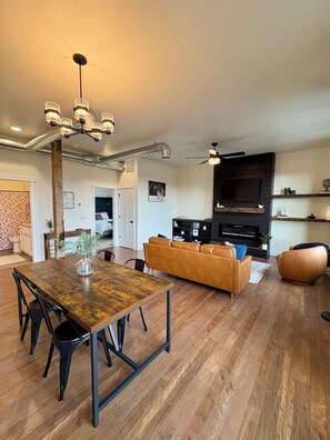 Een moderne woonkamer met een eettafel, bank en tv-meubel.