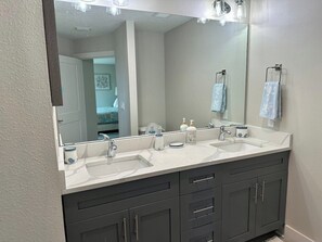 A bathroom with two sinks, a large mirror, and dark cabinets. - Beautiful home near Warm Springs (North Port)