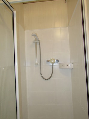 Ducha con cabezal de ducha de mano y grifería empotrada.