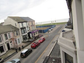 Vista de una calle con edificios, una carretera y un paso de peatones.
