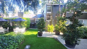 Un giardino curato con patio, mobili da esterno e piante in vaso.