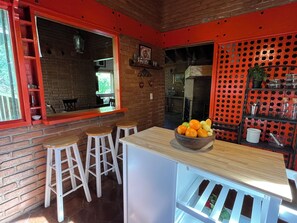 A kitchen with a wooden counter, stools, and a fruit bowl. - House with a spectacular view of the lake, 8 minutes from the Zócalo and downtown. (Valle de Bravo)