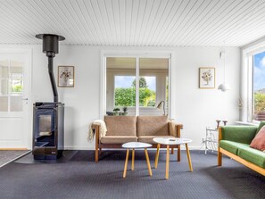 A modern living room with a fireplace, two sofas, a coffee table, and a view of greenery outside. - "Eufemia" - 250m from the sea by Interhome (Haderslev)