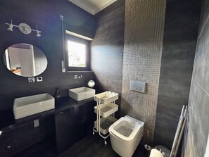 A modern bathroom with a large mirror, a rectangular sink, a toilet, and a small window. - Cascais House - Pool (Parede)