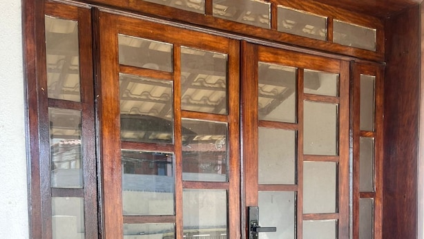 A wooden double door with glass panels and a metal handle. - Zyra's House in Villas - 12 min from the Airport (Lauro de Freitas)